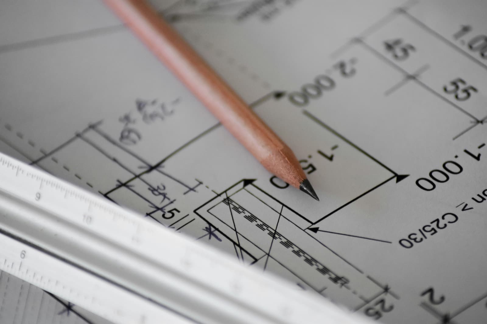 Pencil and scale ruler resting on a technical building drawing