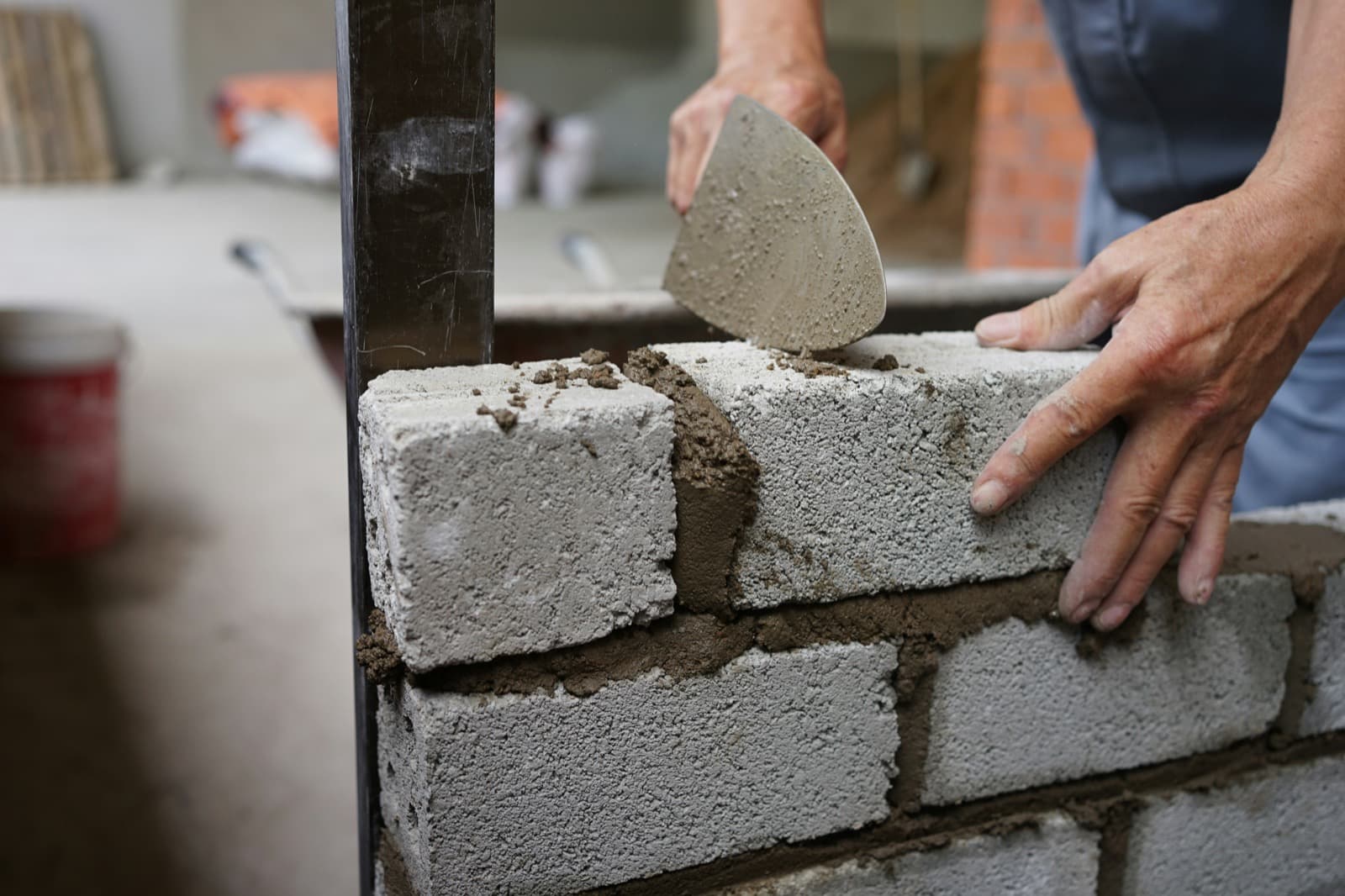 Bricklayer spreading mortar on a new blockwork wall